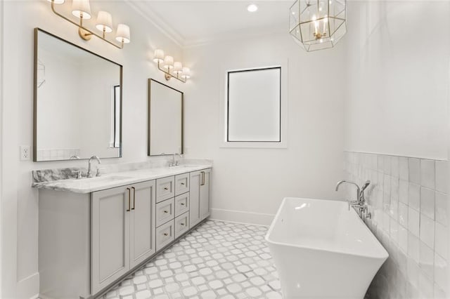 bathroom with vanity, crown molding, and a bath