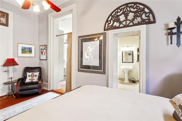 bedroom with connected bathroom and hardwood / wood-style floors