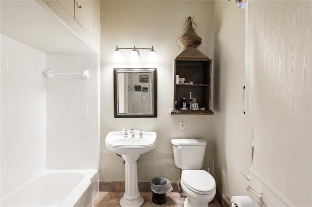 bathroom with tile patterned floors, shower / washtub combination, and toilet