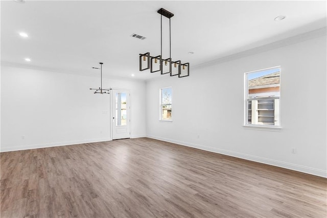 interior space with light hardwood / wood-style floors, a notable chandelier, and ornamental molding