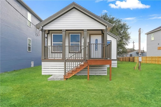 back of property featuring a lawn and a porch