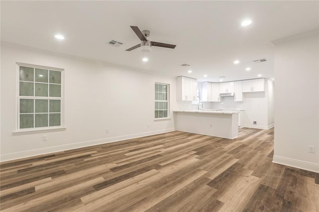 unfurnished living room featuring hardwood / wood-style flooring and ceiling fan