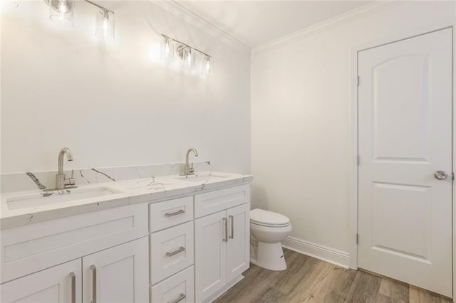 bathroom with vanity, ornamental molding, hardwood / wood-style floors, and toilet