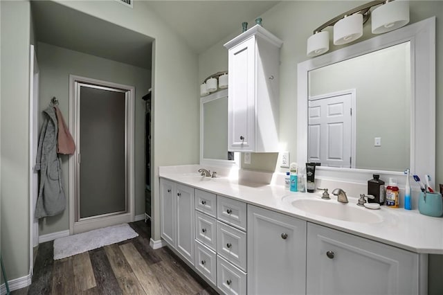 31753 River Pines Dr, Springfield, LA 70462 - bathroom with a shower stall, wood finished floors, a sink, and double vanity