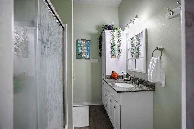 31753 River Pines Dr, Springfield, LA 70462 - bathroom featuring baseboards, vanity, wood finished floors, and a stall shower