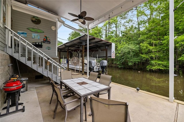 31753 River Pines Dr, Springfield, LA 70462 - view of patio / terrace with a ceiling fan, a dock, outdoor dining area, and a water view