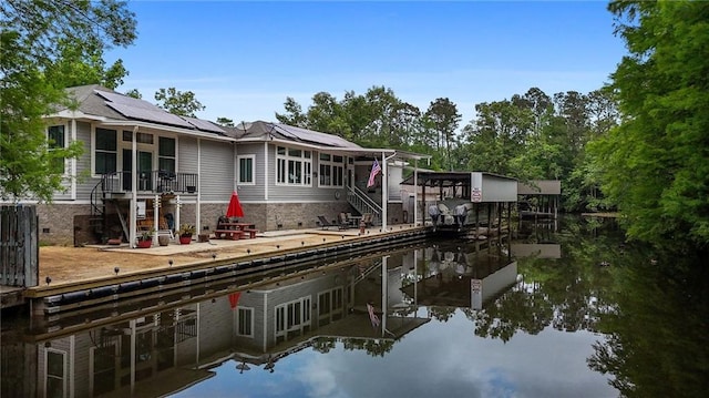 31753 River Pines Dr, Springfield, LA 70462 - rear view of property featuring stairs, a water view, and solar panels