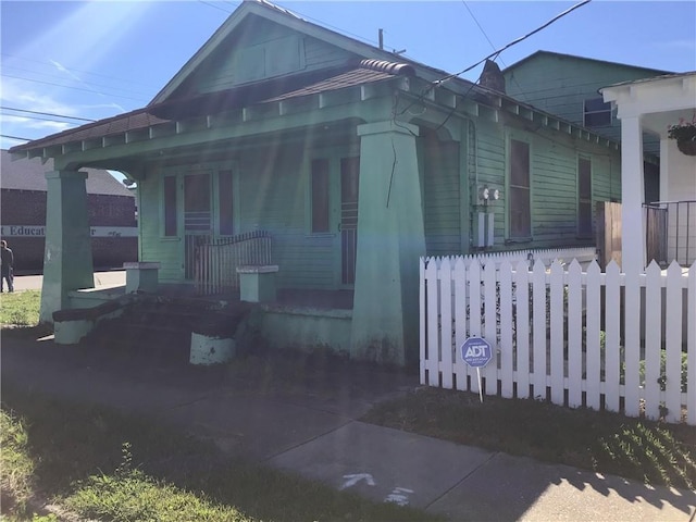 view of front of house featuring covered porch and a fenced front yard