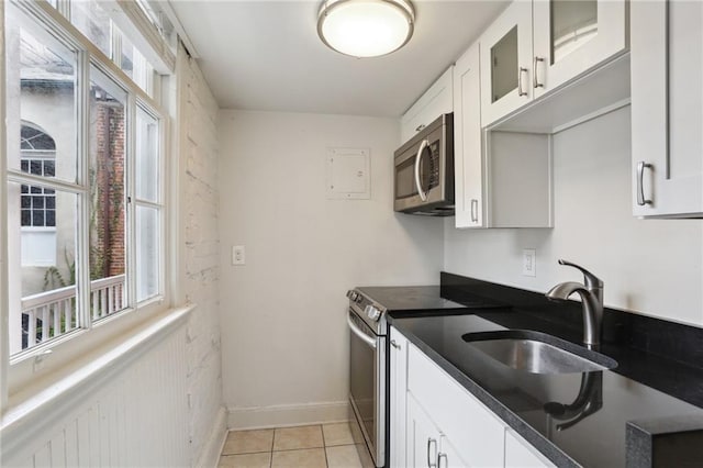 kitchen with light tile patterned floors, sink, white cabinets, and appliances with stainless steel finishes