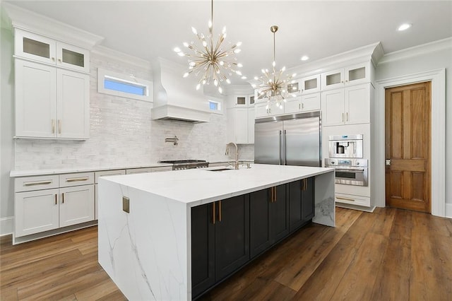 kitchen featuring a kitchen island with sink, white cabinets, stainless steel appliances, and custom exhaust hood