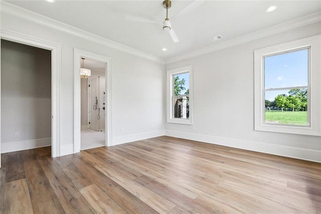 interior space featuring plenty of natural light, wood-type flooring, ornamental molding, and ceiling fan with notable chandelier