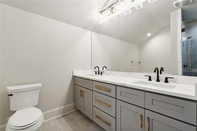 bathroom with a tile shower, tile patterned floors, lofted ceiling, toilet, and vanity