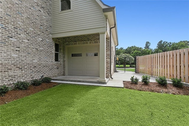 entrance to property with a garage and a yard