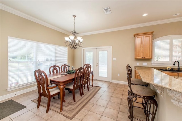 dining room featuring light tile patterned flooring, an inviting chandelier, sink, and ornamental molding