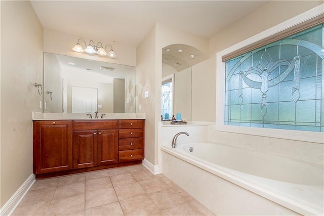 bathroom featuring tile patterned flooring, a tub, and vanity