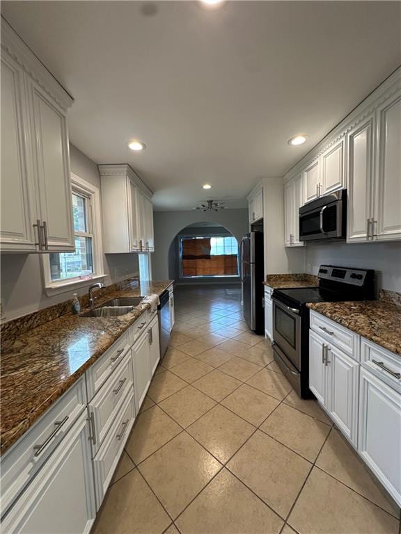 kitchen featuring sink, light tile patterned floors, white cabinets, and stainless steel appliances