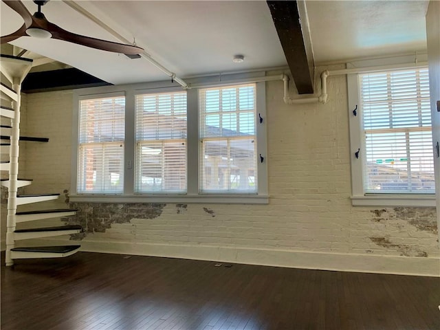 unfurnished room with hardwood / wood-style floors and beam ceiling