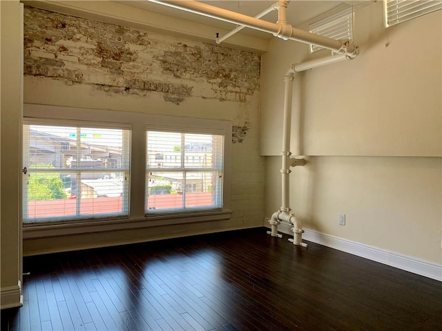 unfurnished room with dark hardwood / wood-style flooring