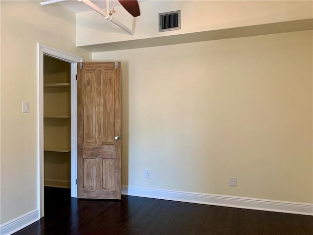 unfurnished bedroom featuring dark wood-type flooring and ceiling fan