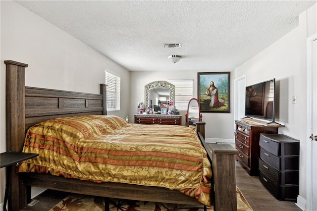 bedroom featuring dark hardwood / wood-style flooring and a textured ceiling