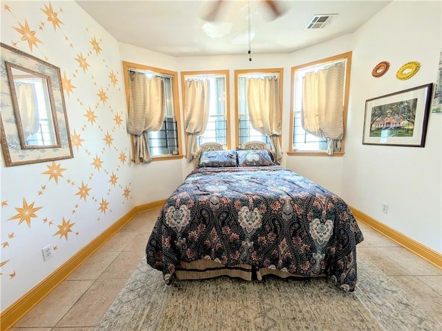 bedroom with ceiling fan and light tile patterned floors