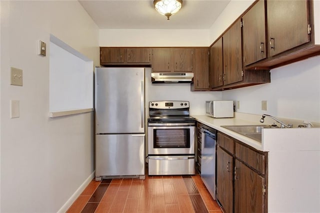 kitchen featuring sink, stainless steel appliances, and dark brown cabinets