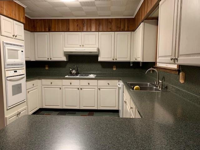 kitchen with white cabinets, white appliances, and sink