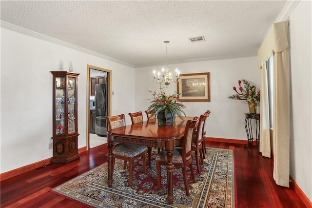 dining room featuring dark wood-style floors, a textured ceiling, visible vents, and an inviting chandelier