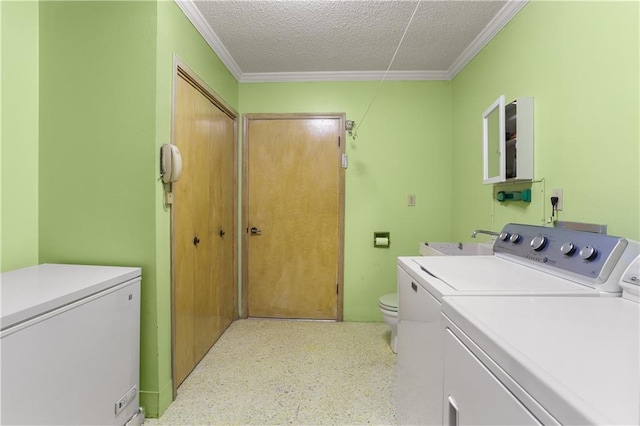 laundry room featuring laundry area, crown molding, a textured ceiling, and washing machine and clothes dryer