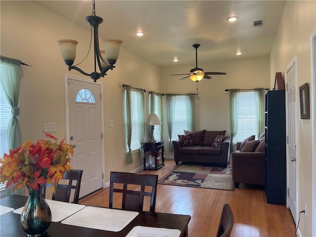 living room with wood-type flooring and ceiling fan with notable chandelier