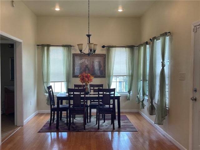 dining room featuring a notable chandelier, a wealth of natural light, and light wood-type flooring