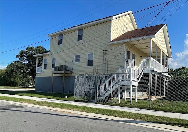 exterior space with central AC unit and a lawn