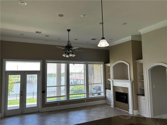 unfurnished living room featuring light tile patterned flooring, a fireplace, built in shelves, and ceiling fan