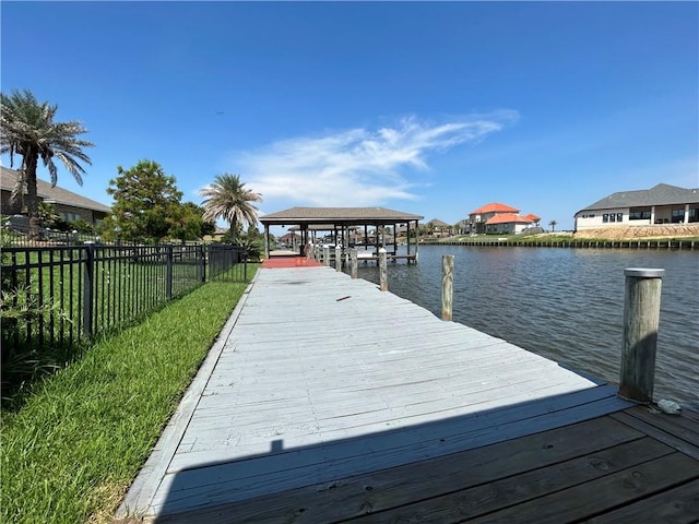 dock area with a water view and a yard