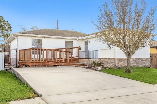 rear view of house featuring a yard and a wooden deck