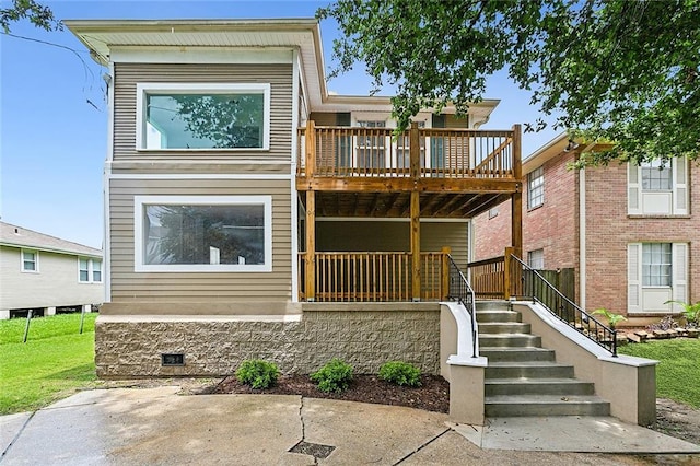 view of front facade featuring a deck and a front yard