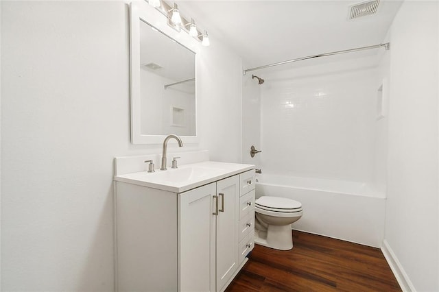 full bathroom featuring hardwood / wood-style flooring, vanity, toilet, and washtub / shower combination