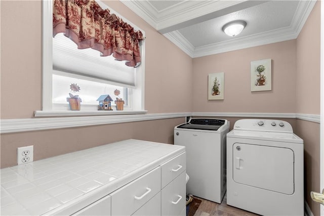 clothes washing area with cabinets, washer and dryer, crown molding, and hardwood / wood-style floors