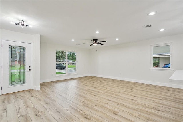 unfurnished living room with light wood-type flooring and ceiling fan