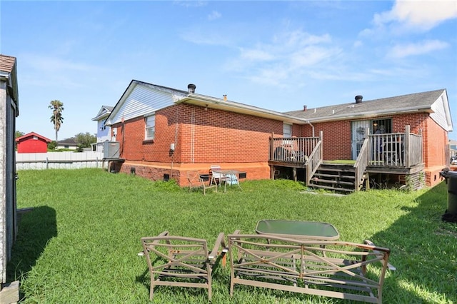 back of house with a deck and a lawn