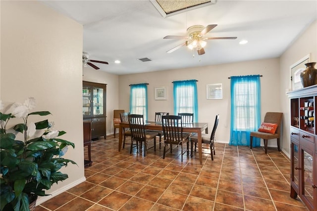 dining area with ceiling fan and dark tile patterned flooring