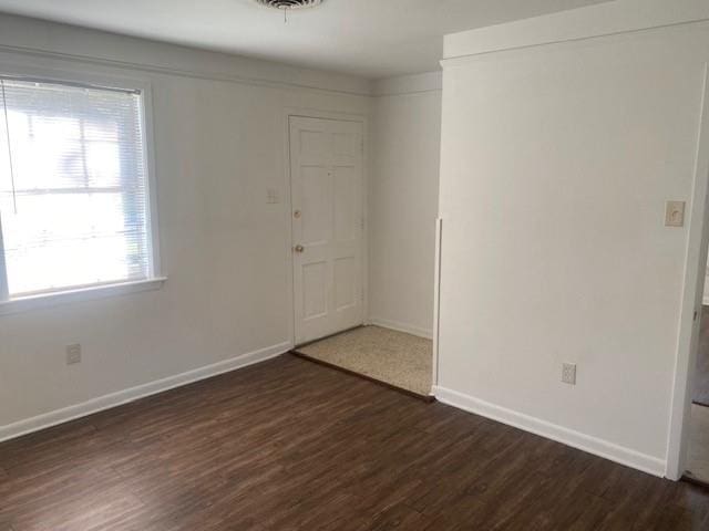 unfurnished room featuring dark hardwood / wood-style flooring