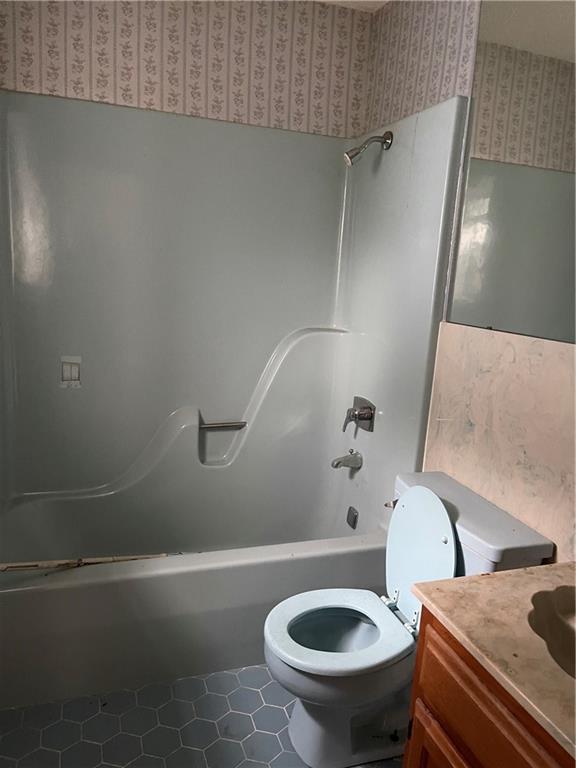 full bathroom featuring vanity, toilet, and  shower combination