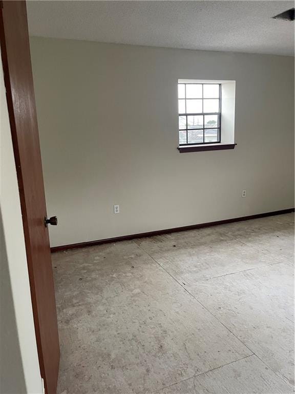 unfurnished room with a textured ceiling