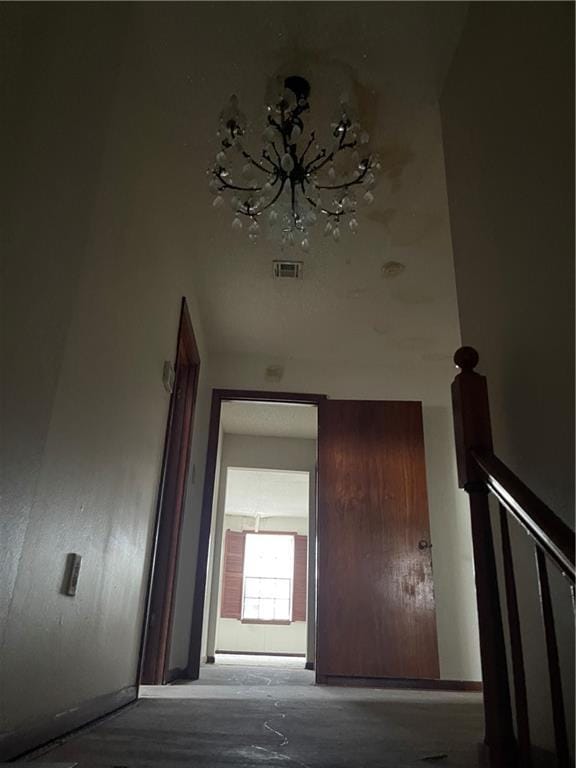 hallway with an inviting chandelier