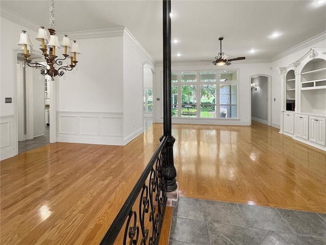 interior space featuring a notable chandelier, wood-type flooring, and ornamental molding