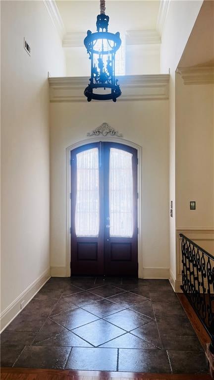 foyer entrance with crown molding and french doors