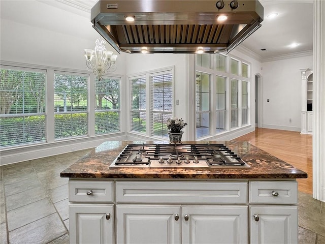 kitchen featuring stainless steel gas stovetop, crown molding, white cabinetry, and island exhaust hood