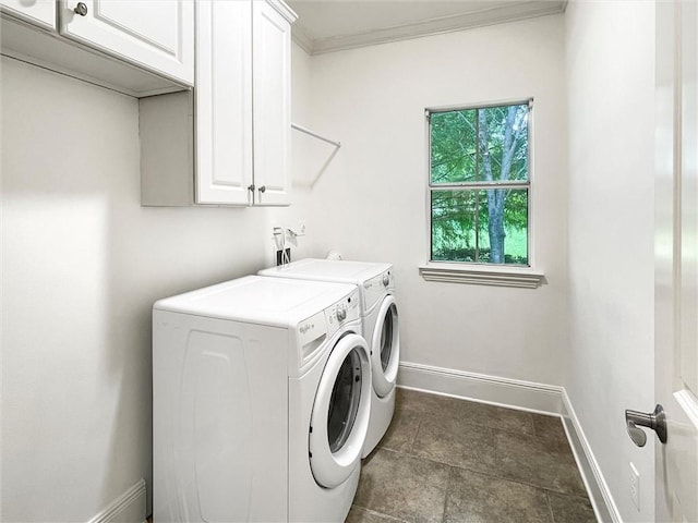 clothes washing area with washer and dryer, cabinets, and ornamental molding