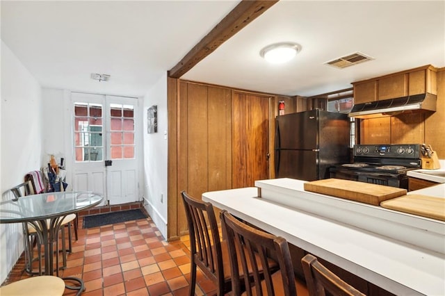 kitchen featuring black appliances, light tile patterned flooring, and beamed ceiling